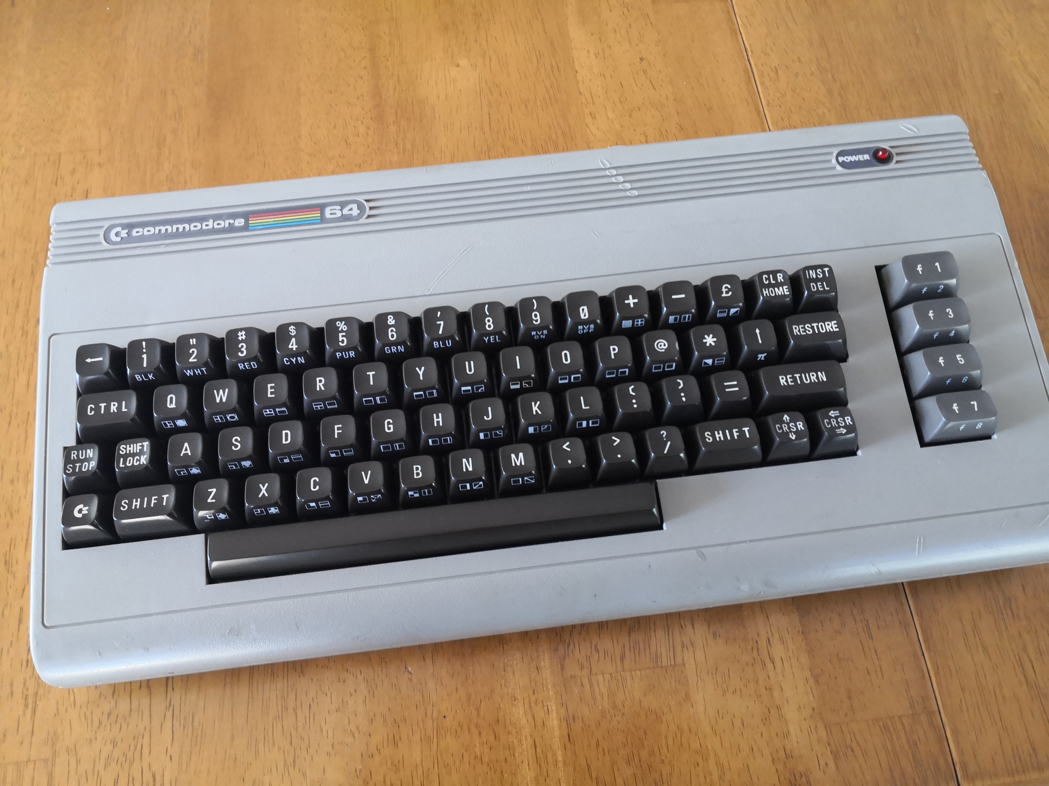 A cleaned up but still old looking Commodore 64 with brown keys